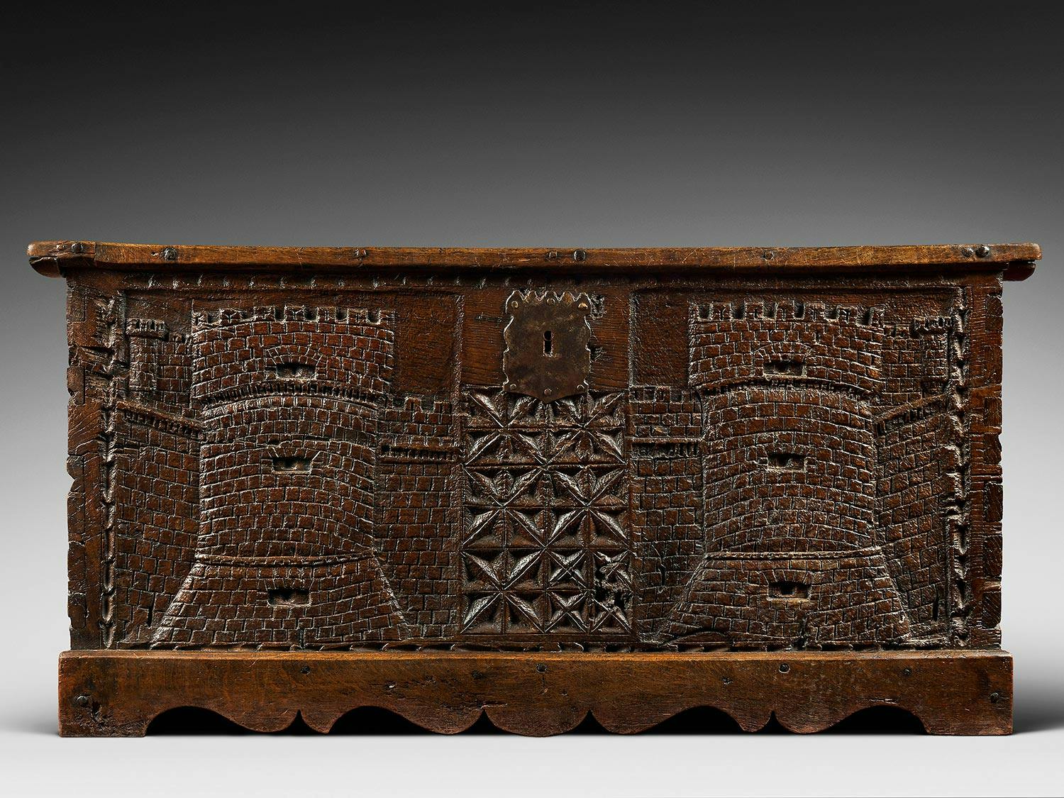 Geschnitzte Holztruhe mit zwei Zinnentürmen