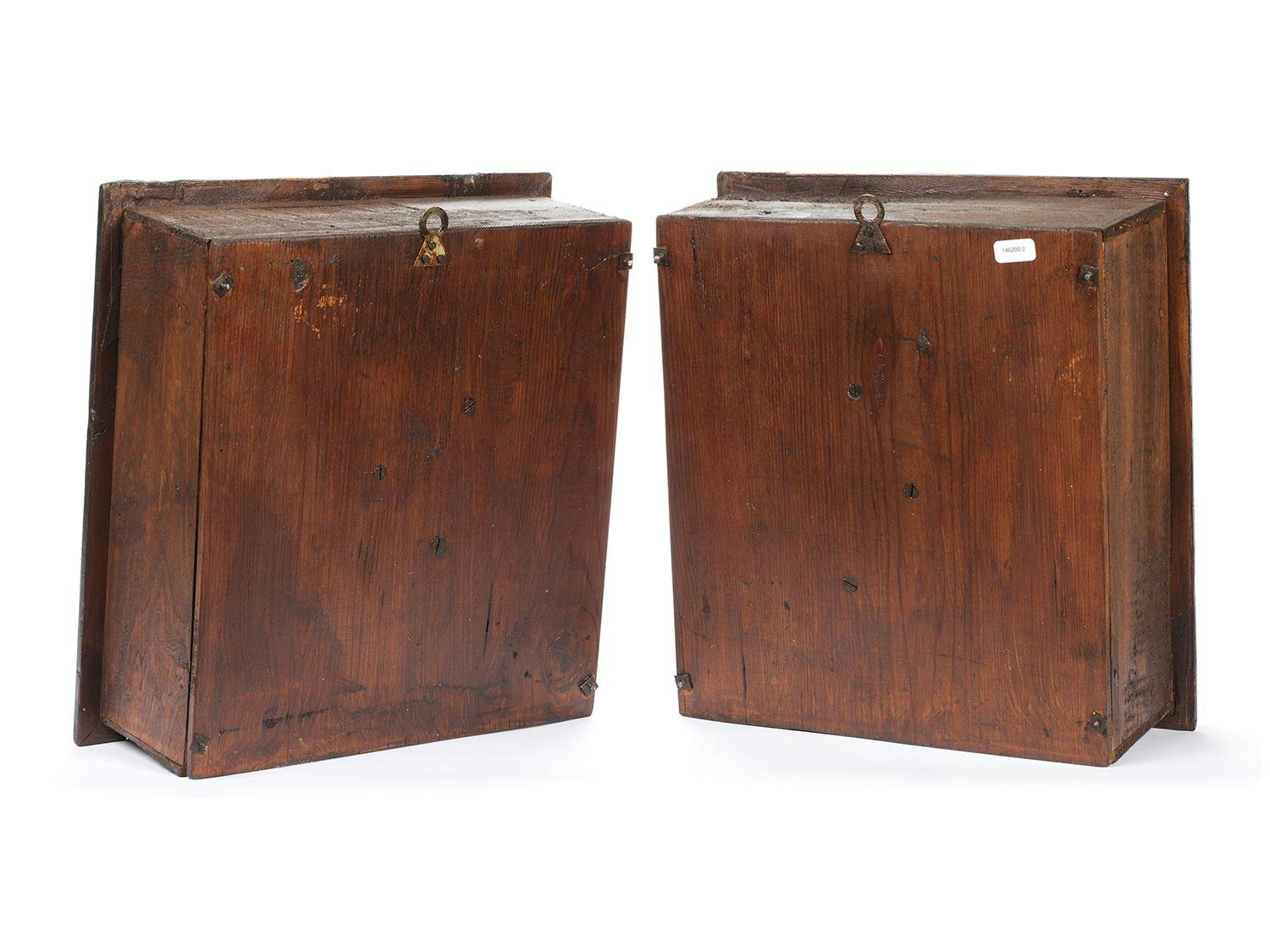 Detailabbildung: Zwei bemalte Holzskulpturen, die jeweils Gesichter eines Teufels mit Hörnern aus Hirschgeweih zeigen